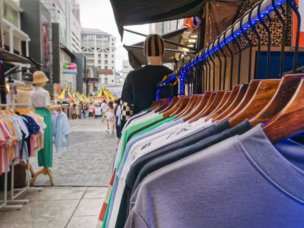 Row of Casual T-Shirts Hanging on Rack at Street Clothing Store