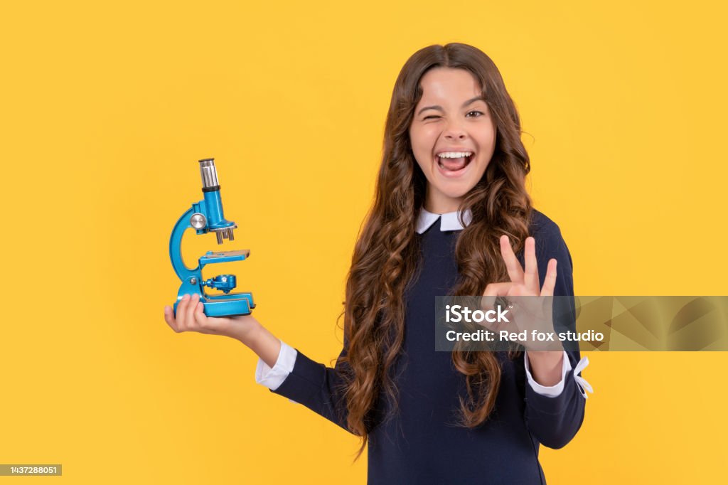happy winking child hold microscope for school education show ok gesture, back to school. happy winking child hold microscope for school education on yellow background show ok gesture, back to school. Back to School Stock Photo