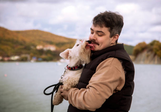 Young man with a dog on a mountain lake