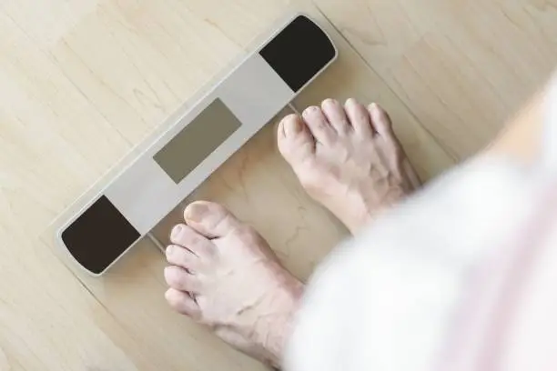 A person standing on the turned-off weighing scale