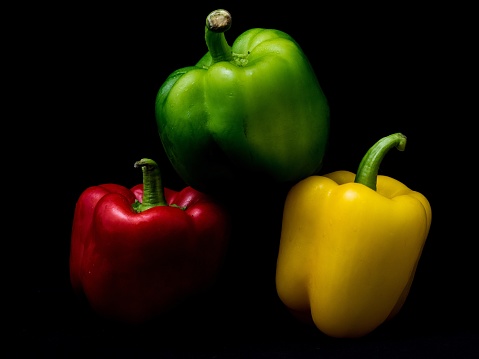 A closeup shot of colorful peppers isolated on a black background
