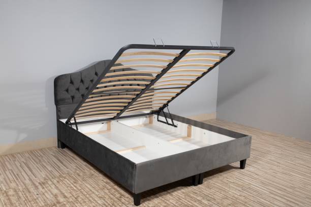 istock Gray bed with a storage space revealed by lifting the wooden slatted base 1437303313