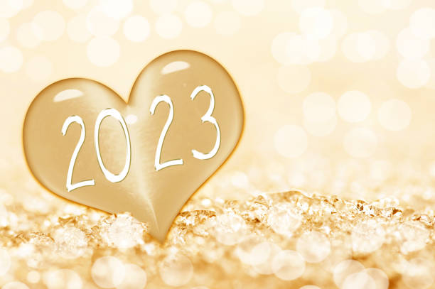 2023 new year card, close up on a ice heart in the snow stock photo