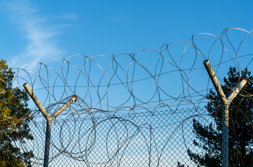 A close-up view of a tall barbed wire fence on the border between Turkey and Bulgaria
