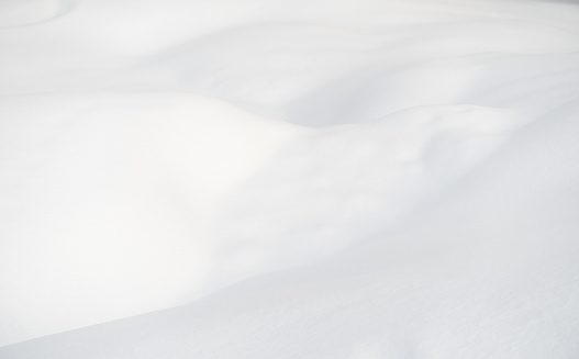 Close-up of a small area of undulating snowdrift, with natural curves in the snow surface.