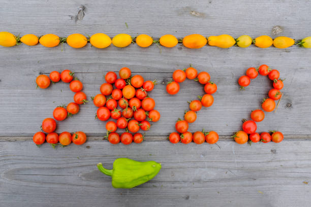 istock Year 2022 from tomatoes, top view. Date stacked from ripe tomatoes on a wooden table for publication, poster, screensaver, wallpaper, postcard, banner, cover, post 1437313439