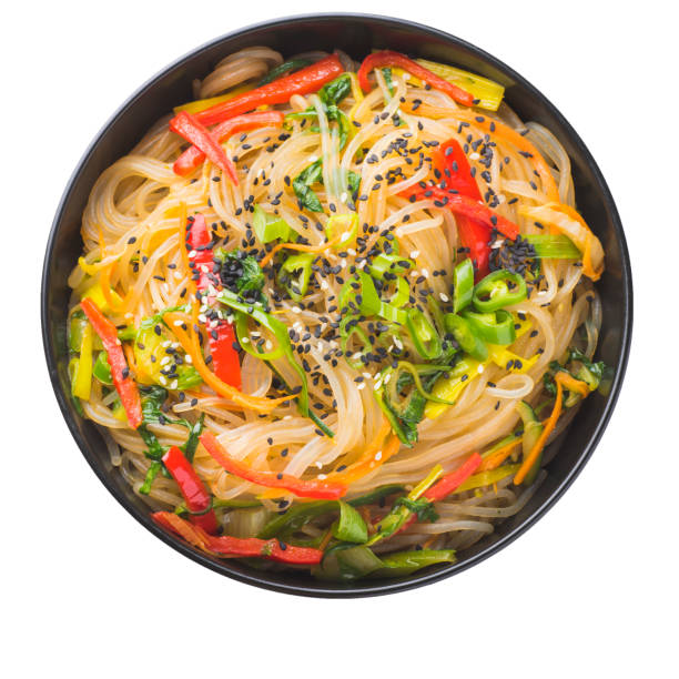 makaron instant w stylu koreańskim japchae lub chapchae w czarnej misce izolowany na białym. kuchnia koreańska szklane danie z makaronem chapchae z warzywami - cellophane noodles zdjęcia i obrazy z banku zdjęć