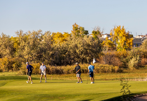 Denver, Colorado - October 19, 2022: On a bright fall day, people play golf in the neighborhood golf course in Denver, Colorado.