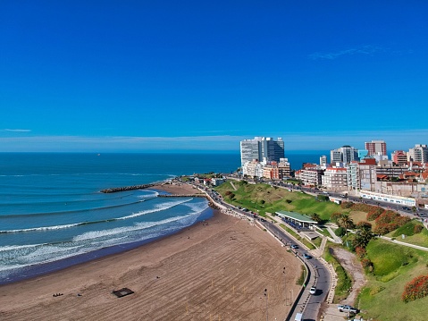 A beautiful view of a coastline with buildings in the background in Mar del Plata, Argentina