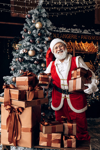 Santa Claus delivering Christmas gifts at home, holidays and celebrations concept