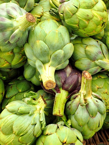 background of green big artichokes for sale at stand