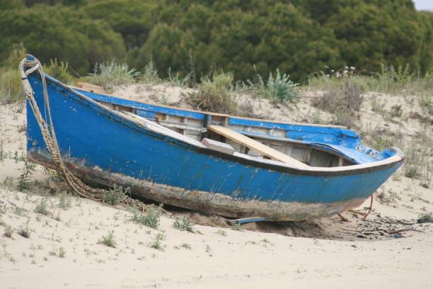 istock Old rusty and weathered blue boat on the sandy beach 1437325412
