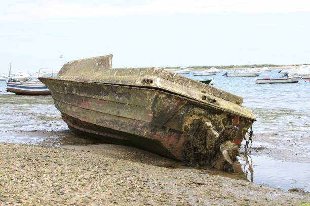 istock Old dirty and muddy boat on the sandy beach 1437325809