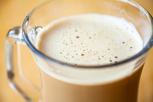 View of a cup of coffee on wooden table.