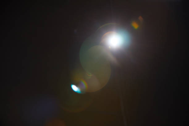 imagem de inflamação de lente natural abstrata no fundo preto - lens flare - fotografias e filmes do acervo