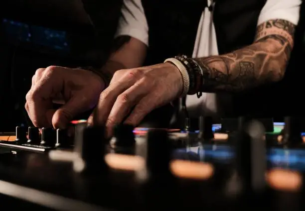 A closeup of a person playing songs and DJing - good for party-related categories