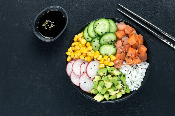 istock Salmon poke bowl: avocado, cucumber, corn, radish. Buddha bowl: rice, salmon, vegetables on a gray background. 1437330474