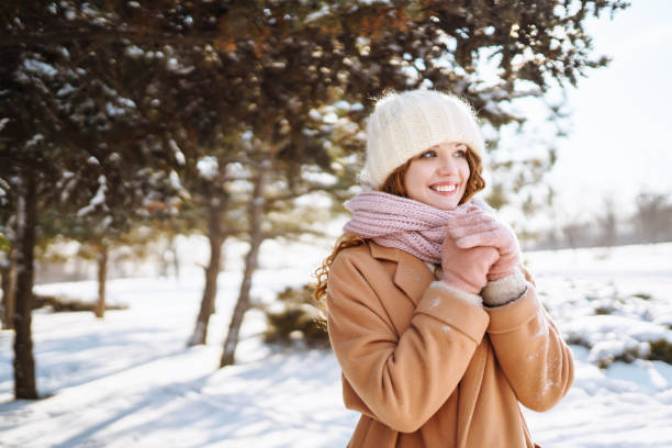 눈 덮인 나무 사이에 서서 첫 눈을 즐기는 아름다운 여자. - russian ethnicity cold relaxation nature 뉴스 사진 이미지