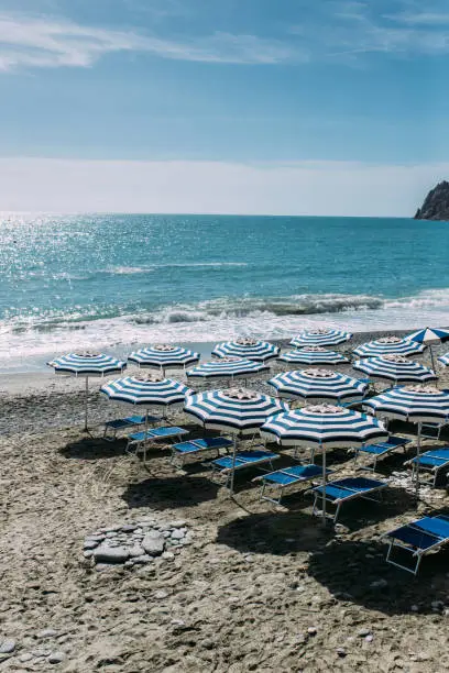 Photo of Beautiful beach with empty beach seat and umbrellas at small town of Monterosso in the Cinque Terre Park in Italy stock photo