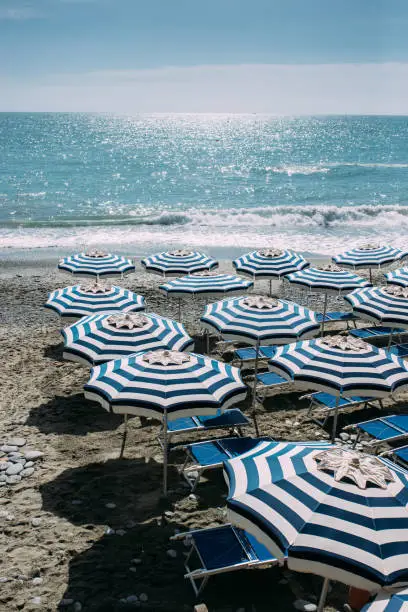 Photo of Beautiful beach with empty beach seat and umbrellas at small town of Monterosso in the Cinque Terre Park in Italy stock photo