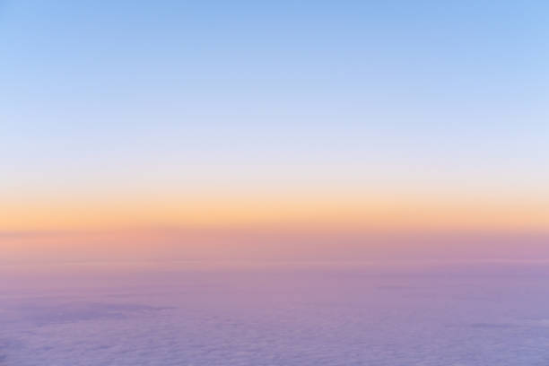 ピンクの紫色の濃い雲の上に明るい黄色の夕日の空撮と青い空、飛行機の上面図 - cloud cloudscape above pattern ストックフォトと画像