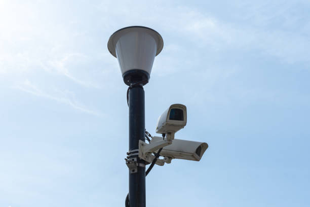istock Surveillance cameras mounted on a lamp post against a blue sky. security cctv camera. Security in the city. 1437336052
