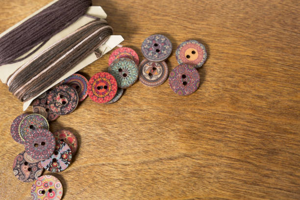 istock LV Colorful buttons and heavy thread on a wooden craft table.  Great background images.  Hobbies. 1437336549