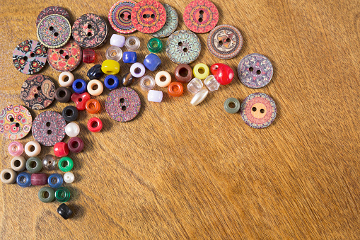 LV Colorful buttons and beads on a wooden craft table.  Great background images.  Hobbies.