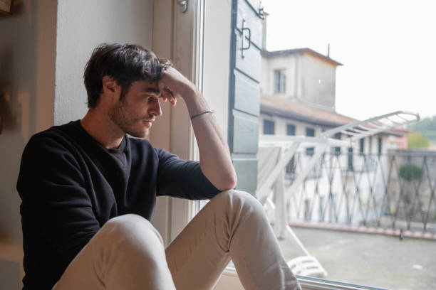 istock Lonely isolated young man sitting on the floor meditating. Depression concept. 1437341762