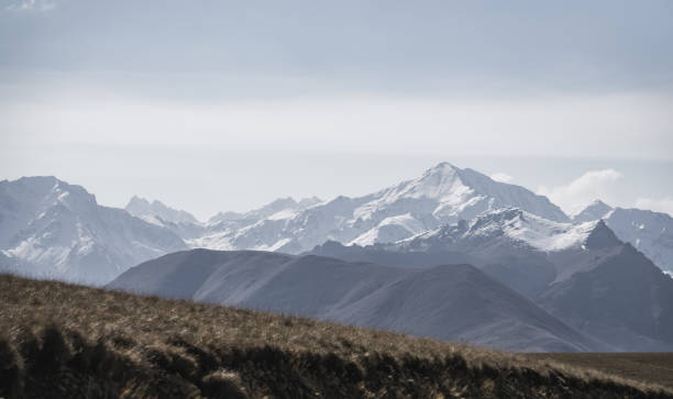 istock Panoramic view of mountain range and peaks with snow, ice and unusual clouds, monochrome landscape with cloudy sky 1437342065