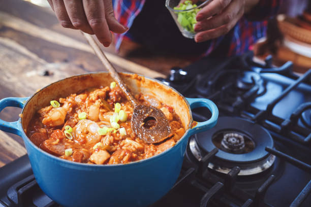 주철 냄비에 케이준 스타일 치킨, 새우와 소시지 잠발라야 준비 - creole food 뉴스 사진 이미지