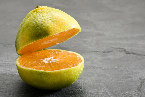 Tangerine, tangerines cut in half on the granite stone background with copy space, still life concepts