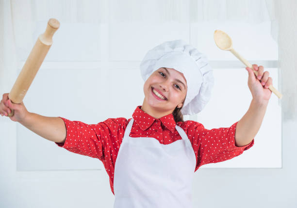 istock kid hold wooden spoon and rolling pin, cooking 1437353451