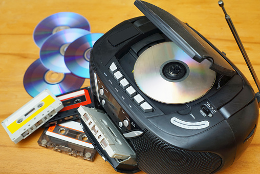 Close up view of CD, radio and audio cassette player with CD and cassettes.