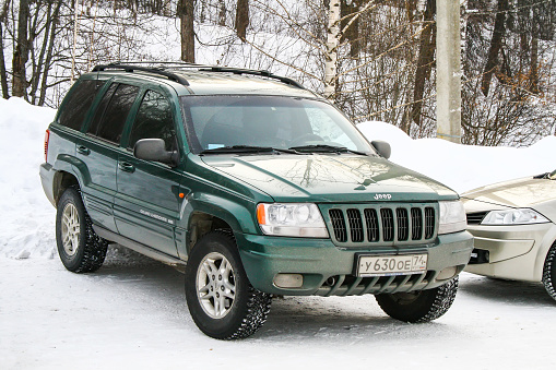 Asha, Russia - January 4, 2011: Green offroad car Jeep Grand Cherokee at the snow covered countryside.