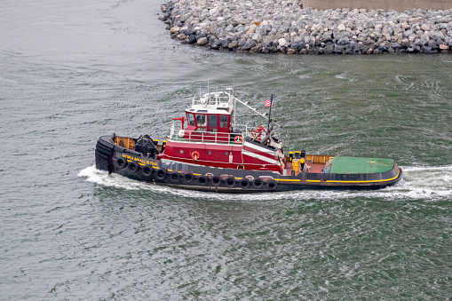 Charleston, SC, USA - October 28, 2022: Moira McAllister, a 30-meter 5000-horsepower twin-screw tugboat owned by McAllister Towing and Transportation, cruises through Charleston Harbor.