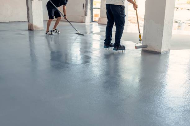 istock Construction workers applying grey epoxy resin in an industrial hall 1437357218