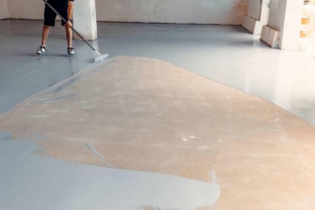istock Construction worker applying grey epoxy resin in an industrial hall 1437357453
