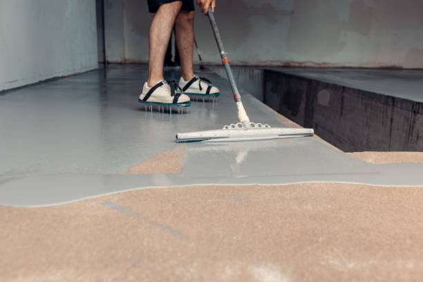 istock Construction worker applying grey epoxy resin in an industrial hall 1437357457