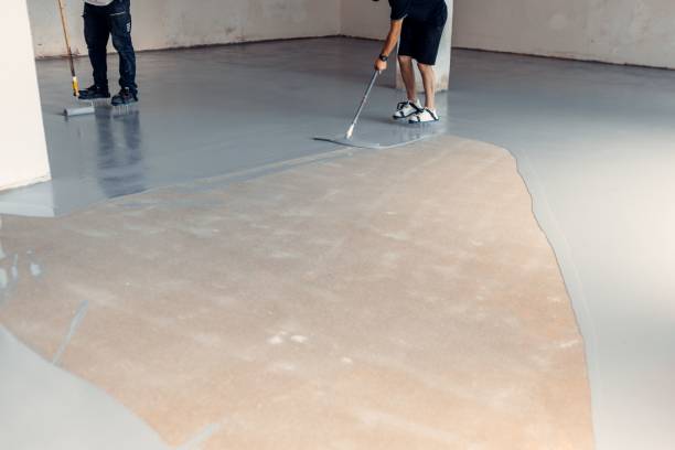 istock Construction workers applying grey epoxy resin in an industrial hall 1437357463