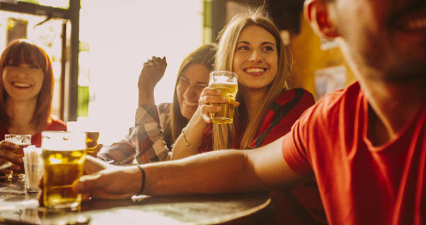 Happy friends group drinking beer at brewery bar restaurant - Friendship concept with young people enjoying time together and having genuine fun at cool vintage pub stock photo