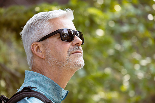 Senior man wearing sunglasses  meditating while looking up into the yonder