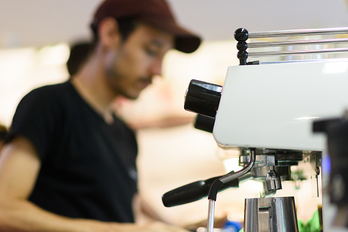 Barista pouring cups into an espresso machine