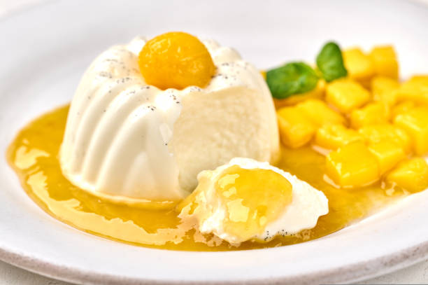 istock Macro panna cotta and piece with natural vanilla pod, mango syrup and mint, selective focus 1437365782
