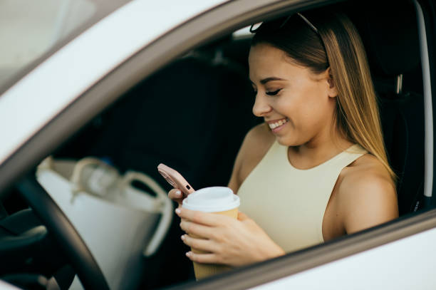 istock Young woman using phone in the car 1437368352