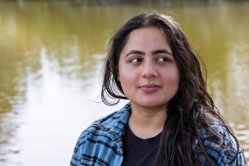 Portrait of Indian young adult outdoors in front of lake in Virginia Beach, Virginia