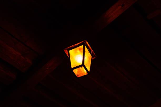 istock Orange lantern hanging on a ceiling and illuminating the darkness 1437368532
