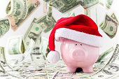 Piggybank in Santa hat with money falling around