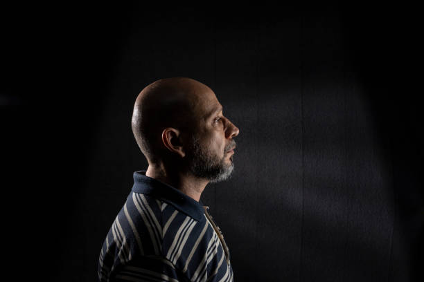 istock Young handsome bald man with beard wearing casual shirt over black background 1437371626