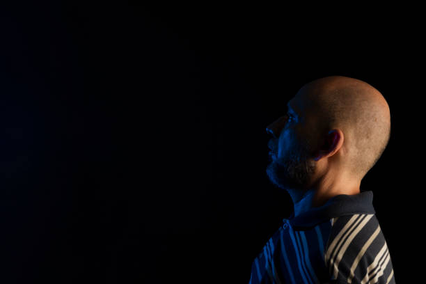 istock Young handsome bald man with beard wearing casual shirt over black background 1437371628